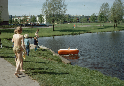 821870 Afbeelding van spelende kinderen met een rubberboot in de vijver van het Park De Watertoren aan de Moezeldreef ...